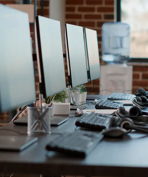 Modern office with neatly arranged computer equipment and headsets, symbolizing efficient IT asset management and tracking of hardware resources within an organization.